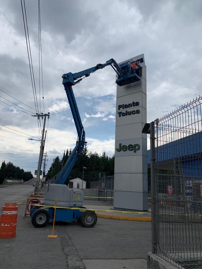 Técnico calser mantenimiento a letrero chrysler